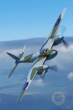 two airplanes flying side by side in the sky with clouds behind them and an emblem on the back