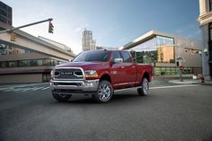 a red ram truck is parked on the street in front of some buildings and traffic lights