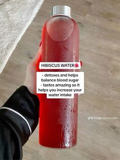 a person holding a water bottle with the caption hibiscus water detoxs and helps to reduce blood pressure so it helps you increase your water intake