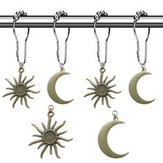 four sun and moon charms hanging from a metal rod with hooks on it's sides