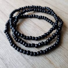 These bracelets are made up of glass seed beads in an opaque black color. Perfect for stacking together, wearing alone, or pairing with a chunky bracelet. The options are endless! (Bracelets sold individually). Great as gifts! Size shown: 7 inches Strung on pre-stretched bracelet material. Affordable Black Beaded Bracelets For Birthday, Minimalist Black Bracelets With Tiny Beads, Minimalist Black Bracelet With Tiny Beads, Black Beaded Bracelet With Tiny Beads As Gift, Minimalist Hand-strung Black Beaded Bracelets, Minimalist Black Hand-strung Beaded Bracelets, Minimalist Black Hand-strung Beaded Bracelet, Black Stretch Bracelet With Tiny Beads As Gift, Handmade Black Friendship Bracelets With Round Beads