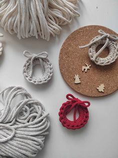 several pieces of white and red yarn are laid out on top of a cork board