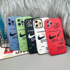 four nike phone cases sitting next to each other on top of a book case in front of a furry animal