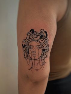 a woman's arm with a black and white tattoo design on her left shoulder