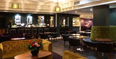 a room filled with lots of tables and chairs next to each other in front of a bar