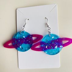 Get ready to take your love for the outer space to the next level with our new product 'None' - a pair of stunning purple and blue Saturn resin earrings! These earrings are perfect for anyone who adores all things space-related. Crafted from high-quality resin, these earrings are designed with utmost attention to detail, ensuring that every aspect of Saturn's appearance is captured perfectly. The glittery finish adds a touch of sparkle and glamor that will make you shine at any event. Featuring hypoallergenic ear posts, you can wear these earrings without any fear of irritation or discomfort. Plus, the unique design is sure to grab everyone's attention while complementing your outfit perfectly. Whether you're heading out for a night on the town or looking for something fun and unique to we Aesthetic Pleasing, Galaxy Aesthetic, Space Earrings, Saturn Planet, Space Girl, Resin Earrings, Earrings Blue, Outfit Aesthetic, Outer Space