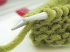 a crochet hook with a needle in it and yarn on the other side