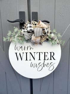 a sign that says winn winter wishes hanging on a door with wreaths and bows