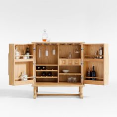 a wooden cabinet with bottles and glasses in it's doors open to show the contents