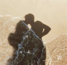 the shadow of a person standing next to a surfboard