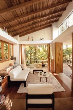 a living room with wooden ceilings and white furniture