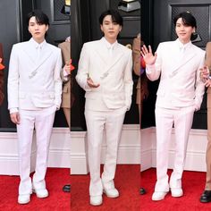 three men in white suits standing on a red carpet