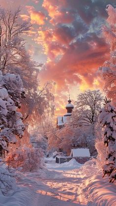 the sun is setting over a snow covered road with trees and houses in the background