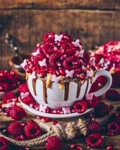 a cup filled with chocolate and raspberries on top of a table