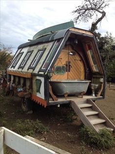 an unusual house built into the back of a truck with stairs leading up to it