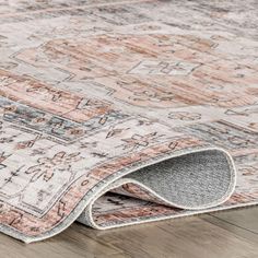 an area rug on the ground with wood flooring and wooden floors in the background