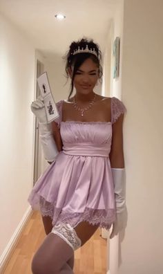 a woman in a short purple dress and white gloves is posing for the camera with her leg up