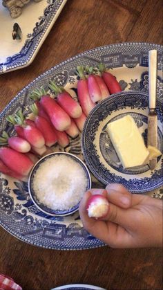 a plate with some food on it and someone holding a spoon in front of it