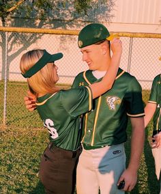 two baseball players are hugging each other on the field with their arms around one another