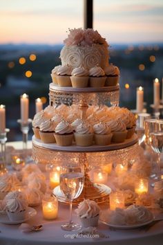 cupcakes and candles are arranged on a table in front of a window at sunset