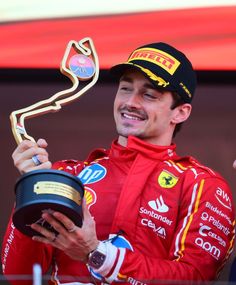 a man holding up a trophy on top of a podium