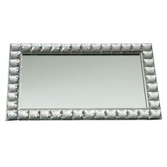 a mirror that is sitting on top of a white surface with riveted edges