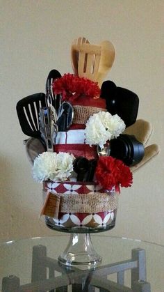 a glass table topped with a cake covered in lots of utensils and flowers