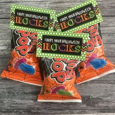 three bags of rock'n'roll halloween candy on a wooden table with green and white polka dots