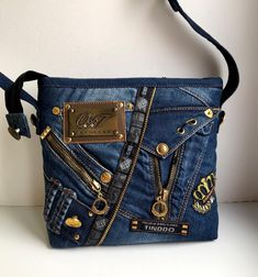 a denim purse with gold zippers on it