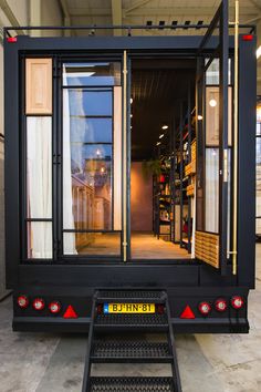 a black truck with its doors open on the side and stairs leading up to it