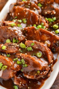 the meat is covered in sauce and green onions