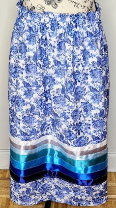 A Native American White and Blue Floral Paisley Cotton Calico Ribbon Skirt made with 7 different colored ribbons which consist of dark blue, royal blue, ocean blue, turquoise, light blue, light gray and white ribbons. Skirt is made with hidden pockets, one channel waistband with small ruffle above elastic and elastic waist band. Skirt comes at 36 inches long but can also be made to custom sizes. Please use the personalization section to enter your personal measurements: waist, hips and length of Blue Silk Lined Bottoms, Blue Silk Lined Skirt, Blue Gathered Mini Skirt, Blue Mini Skirt With Gathered Detail, Blue Silk Skirt For Spring, Blue Silk Skirt, Ribbon Skirt, Ribbon Skirts, Skirt Floral