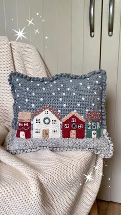 a pillow with houses on it sitting on a chair