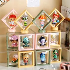 a collection of little figurines on display in front of a wall mounted shelf