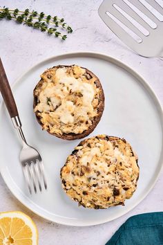 two muffins on a plate with a fork