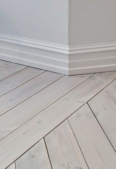 an empty room with hard wood flooring and white walls