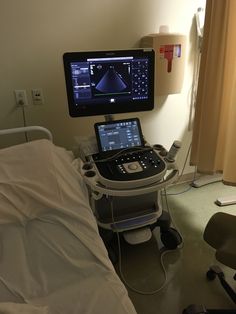 a hospital room with a laptop and monitor