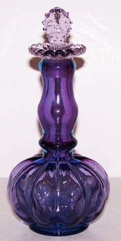 a purple glass vase sitting on top of a table