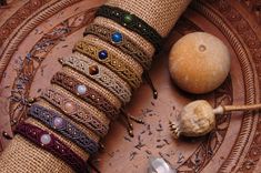 a bunch of bracelets sitting on top of a wooden table next to an object