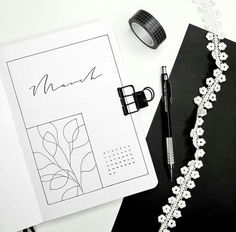 a notepad, pen and some other items on top of a black notebook with white writing