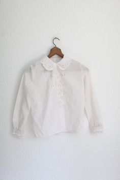 small fit shoulders:14 1/2" pit to pit:19" length:22" sleeve:21" gently used vintage condition. White Embroidered Blouse With Peter Pan Collar, Classic Embroidered Button-up Blouse, Vintage White Shirt With Button Closure, Classic White Tops With Peter Pan Collar, Classic White Top With Peter Pan Collar, Vintage Lace Collar Button-up Top, White Classic Shirt With Ruffled Collar, Classic White Shirt With Ruffled Collar, White Retro Top With Ruffled Collar