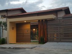 the front entrance to a modern home with wooden slats on it's doors