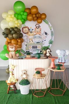 an assortment of balloons and decorations for a baby's first birthday party on a green carpet