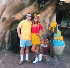 a man and woman standing in front of a fake tree at disney's animal kingdom