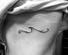 a black and white photo of a woman's stomach with a wave tattoo on it