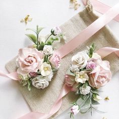 two pink and white flowers sitting on top of a piece of cloth