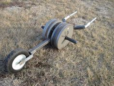 a barbell is laying on the ground with two wheels attached to it, and there are no people around