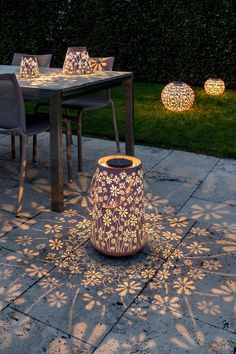 an outdoor table and chairs with lights on them