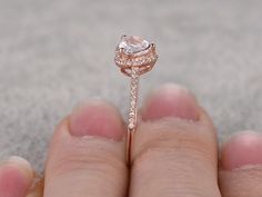 a close up of a person's hand holding a diamond ring