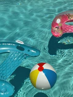 two inflatable toys floating on top of a pool next to a life preserver